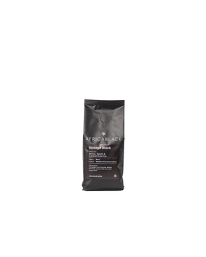 A sleek black bag of africablock vintage black coffee beans with minimalist white text from central america